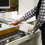 Cropped shot of milling machine operator at his workplace. Middle aged man working at plant. Automation and machinery concept