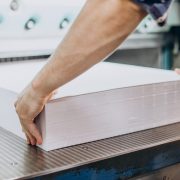 Man working in printing house with paper and paints